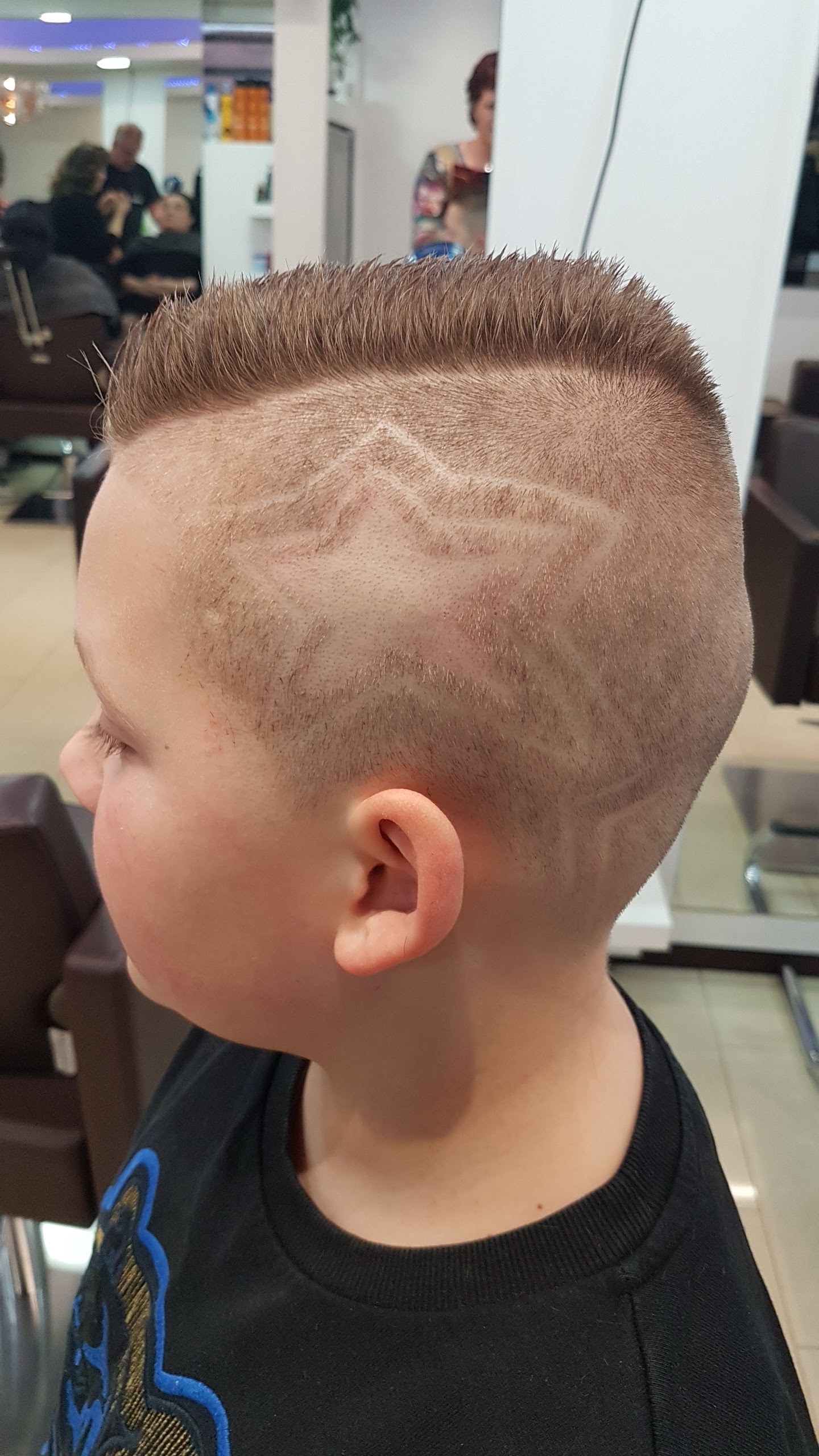 Jongen met kort opgeschoren haar en een ster in de zijkant geschoren